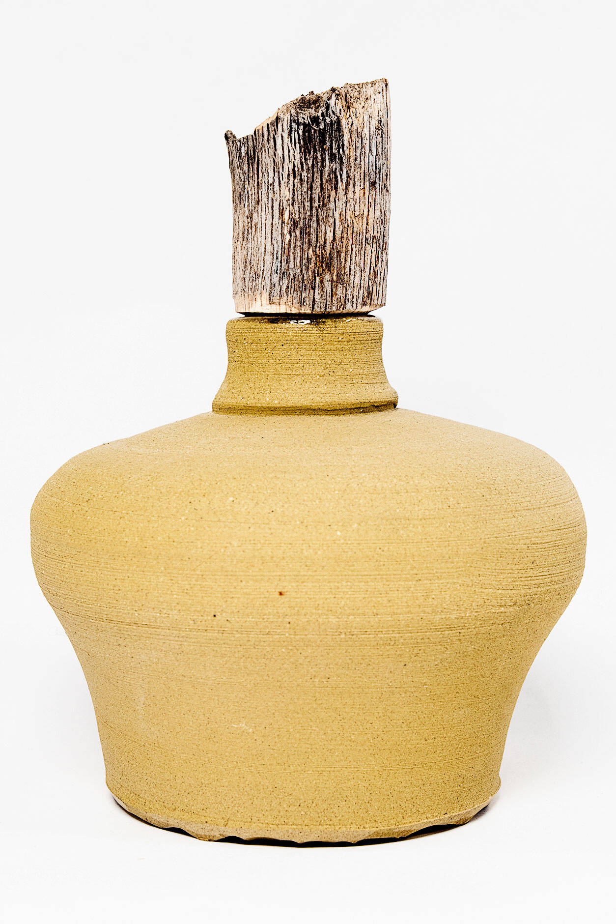 Small, stout clay bottle in a yellow orange color. Topper is made from untreated wood.